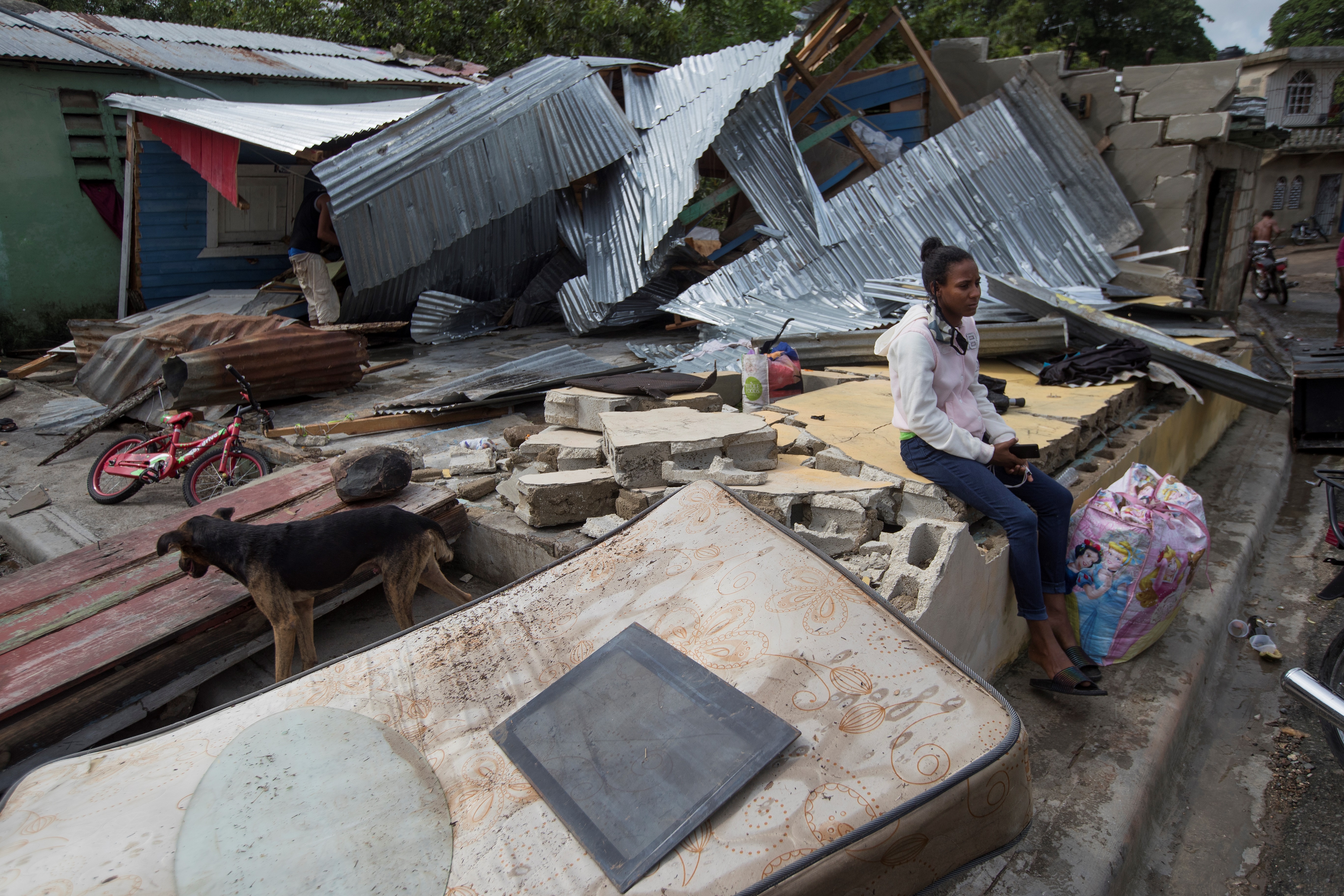 Una niña permanece sentada en medio de las ruinas de su casa tras el paso del huracán Isaías en Hato Mayor (República Dominicana). EFE/ Orlando Barría